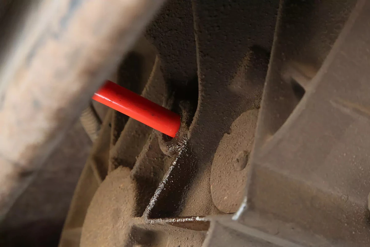 The red filler hose from a transfer pump inserted into the transfer case.