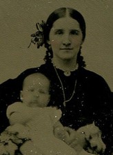 CIVIL WAR ERA  TAX STAMP TINTYPE.WOMAN WITH RIBBON IN HER HAIR AND BABY ON LAP. 