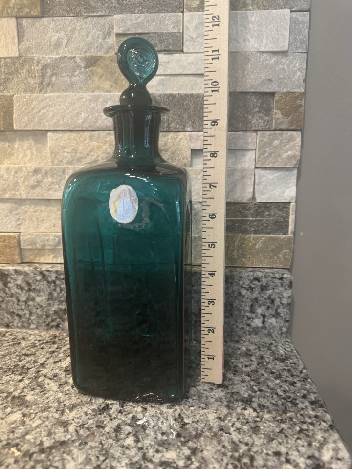 Blenko glass is American art glass royalty — a teal Williamsburg Restoration piece with stopper is a legitimate collectible conversation starter.