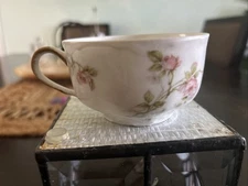 A Haviland France China Tea Cup. The Base Is White With Multicolored Flowers.