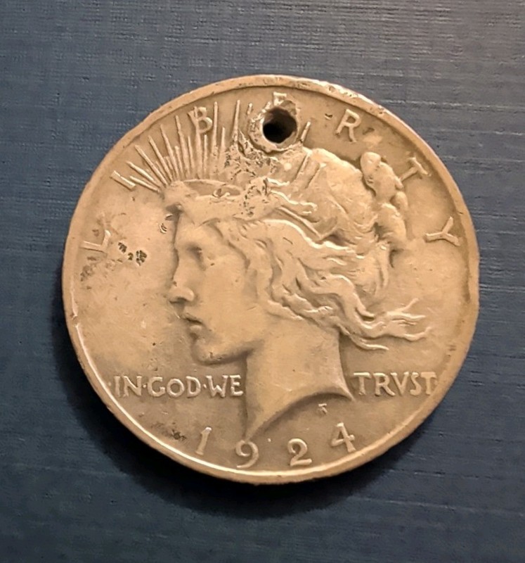 1924 peace silver dollar hole drilled in top. well circulating