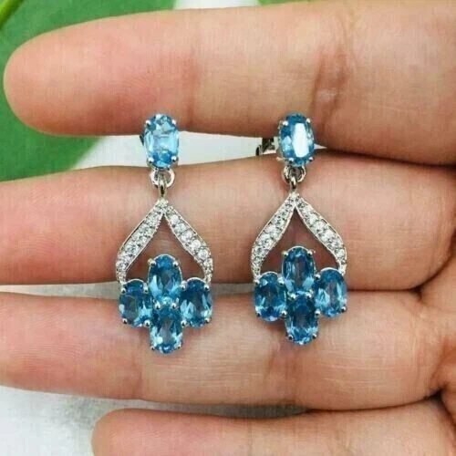 Pendientes colgantes de topacio azul creado en laboratorio de corte ovalado de 2,1 quilates para mujer enchapados en oro blanco de 14 quilates Foto 3 de 4