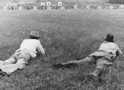 Two figures prone position aiming rifles targets shaped like men,  Old Photo