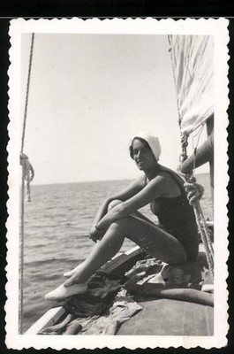 Fotografie junge Frau im Badeanzug auf einem Segelboot sitzend 