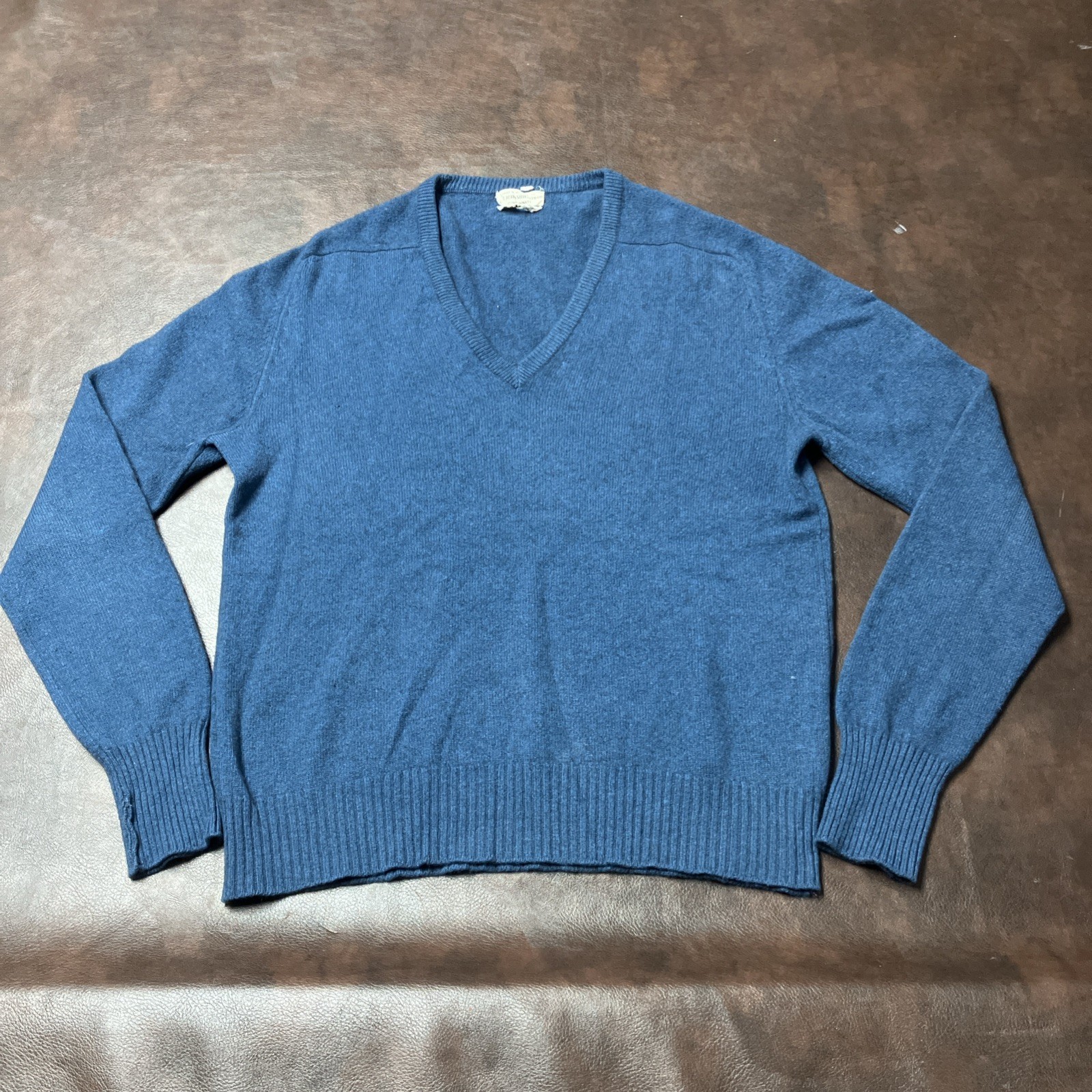 Slate blue cashmere V-neck sweater, laid flat.