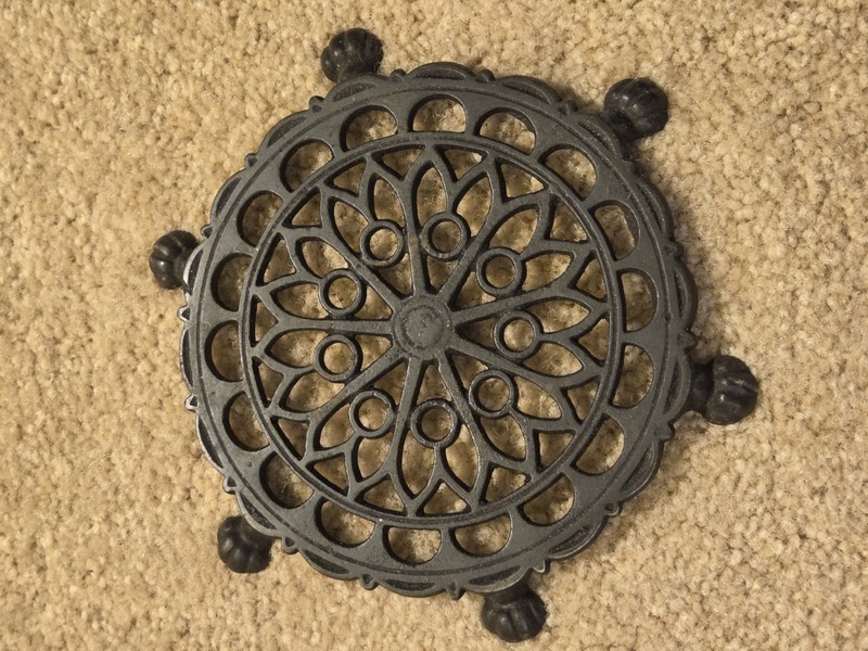 Vintage round cast iron trivet, paw footed, geometric design