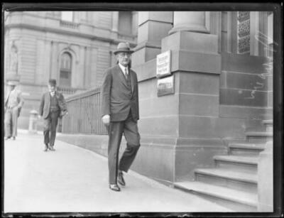 Mr. R.W. Weaver walking outside steps of the Treasury Building, Sy - Old Photo