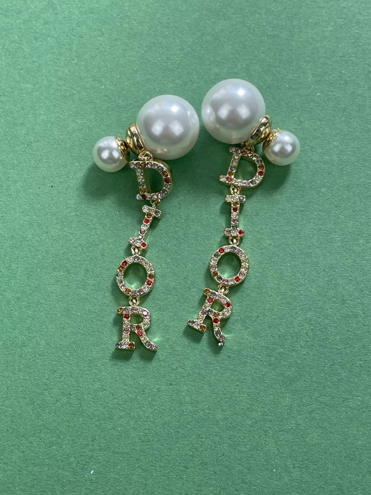 Boucles d'oreilles pendantes Dior dorées charmantes monogramme