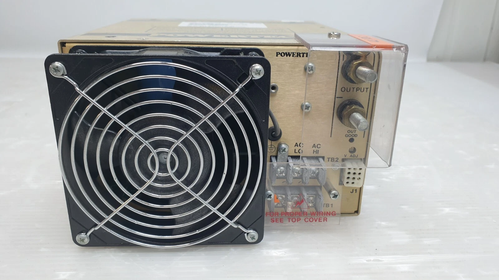 Front panel close-up: AC LO / AC HI terminals, output studs, OUT GOOD, V ADJ and J1