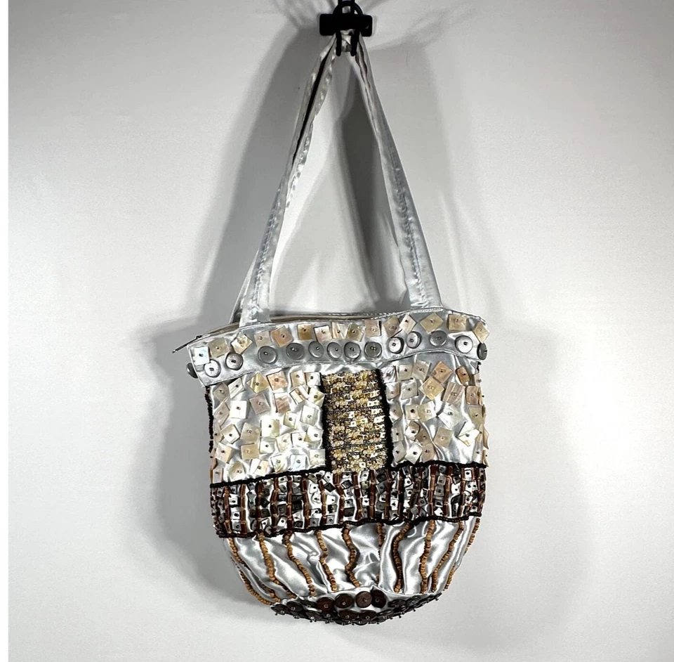 Cartera artesanal de satén plateada con adornos de botones y cuentas Foto 2 de 4