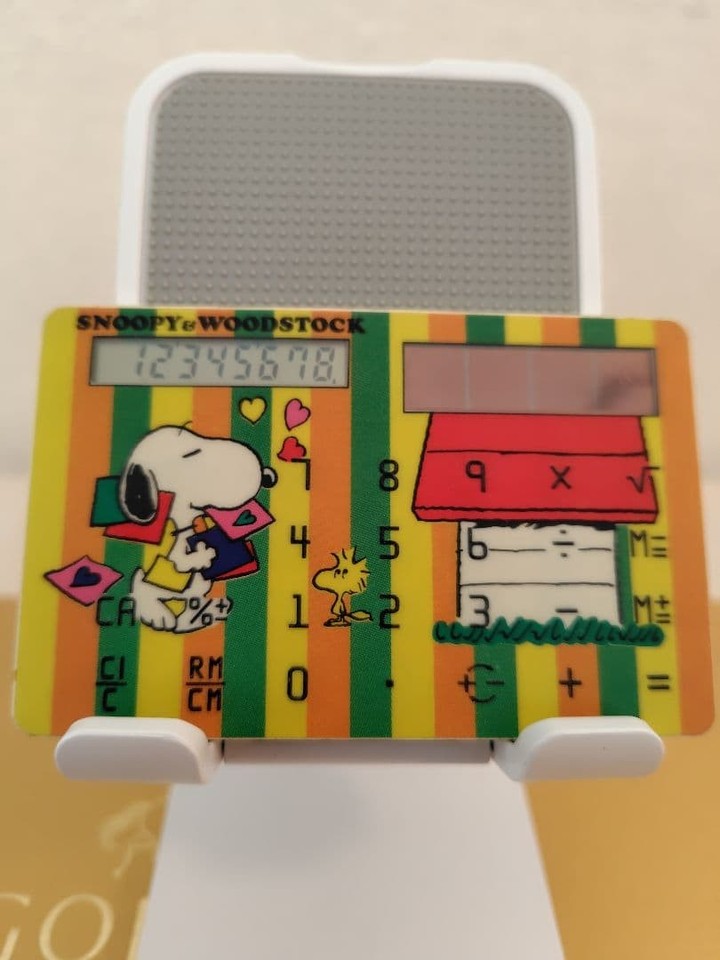 A Canon calculator styled with Snoopy and Woodstock — retro Japanese character merch meets functional office gadget, impossibly charming.