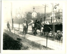AMERICANA, MEN WITH HORSE AND WAGON ON PAVED ROAD, SIDEWALK. 