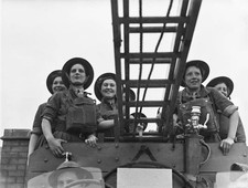 Group of volunteering ATS firefighters sit on their fire engine du- Old Photo