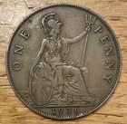 1936 silver One Penny coin showing Britannia seated with spear and shield, text “ONE PENNY” and date “1936” on edge.