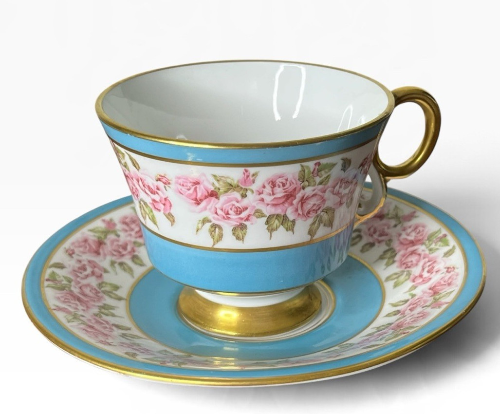 White bone china teacup and saucer with a floral pattern and gold rim trim.