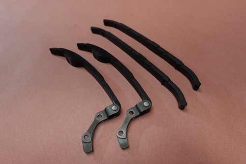 Black 1998-2015 Yamaha VStar V Star 650 XVS650 cam camshaft timing chain guides with silver metal ends on a brown surface.