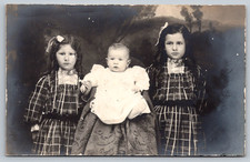 RPPC c1910s Three Children Portrait Girls Plaid Dresses Holding Baby Postcard