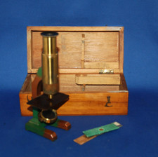 A 19th century pillar type brass microscope, attached lens, box, small slides