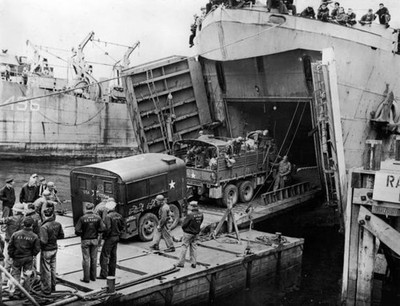 Heavy truck pulls a field kitchen up bow ramp of an LST during inv- Old Photo