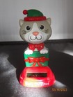 Solar Christmas Holiday Style Cat popping out of a present wrapped in green red