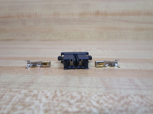 Black Fanuc A08B-0088-K050 connector kit with two silver metal terminals and gold contacts on a light wood surface.