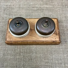 PAIR OF ANTIQUE DOLLY TOGGLE COPPER LIGHT SWITCHES MOUNTED ON WOODEN PATTRESS