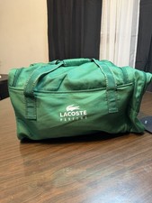green Lacoste Parfums promotional duffle bag featuring brand's crocodile logo.