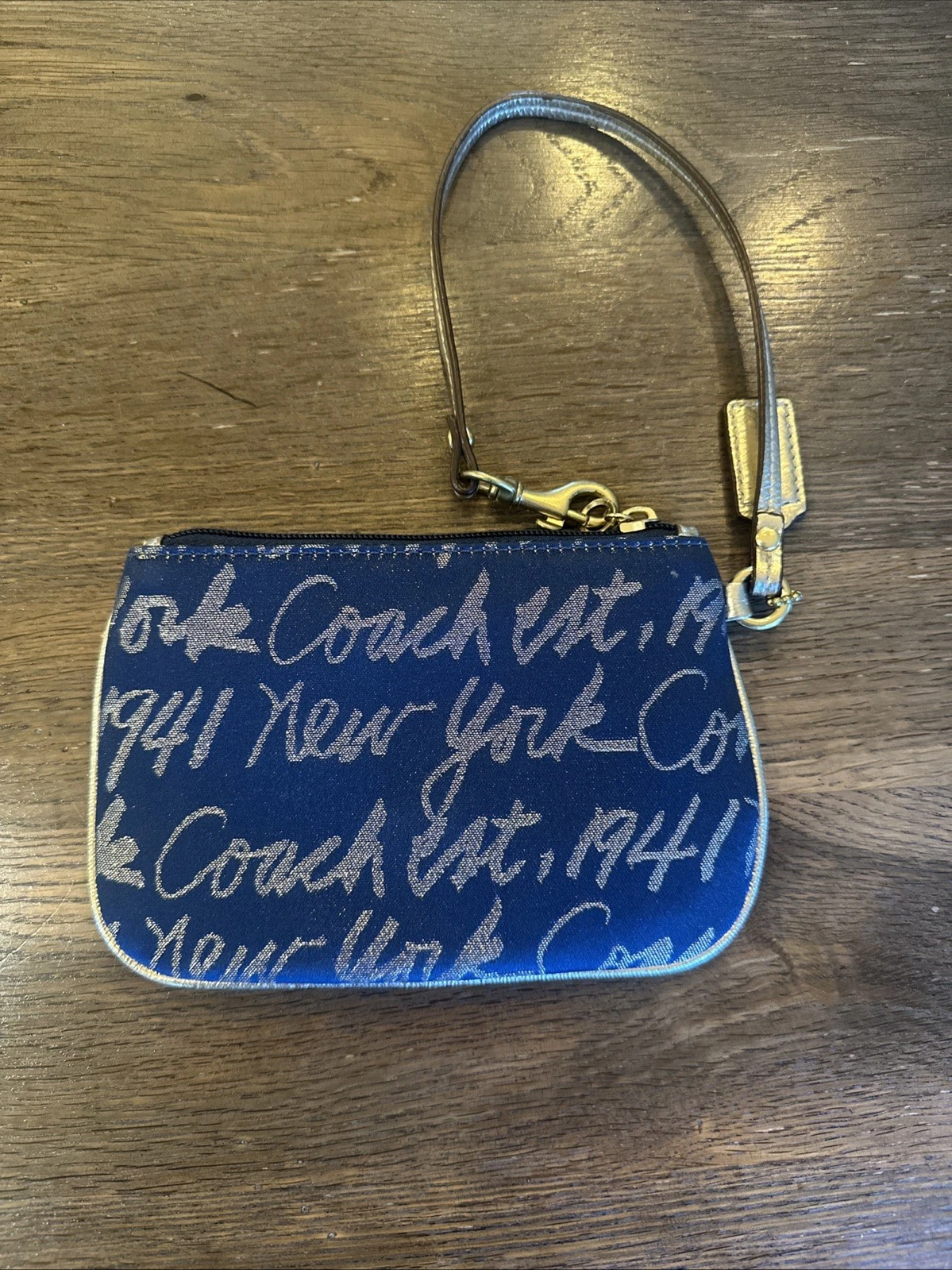 Coach Wristlet donna New York scritta blu navy con cuore oro e bordo in pelle oro
