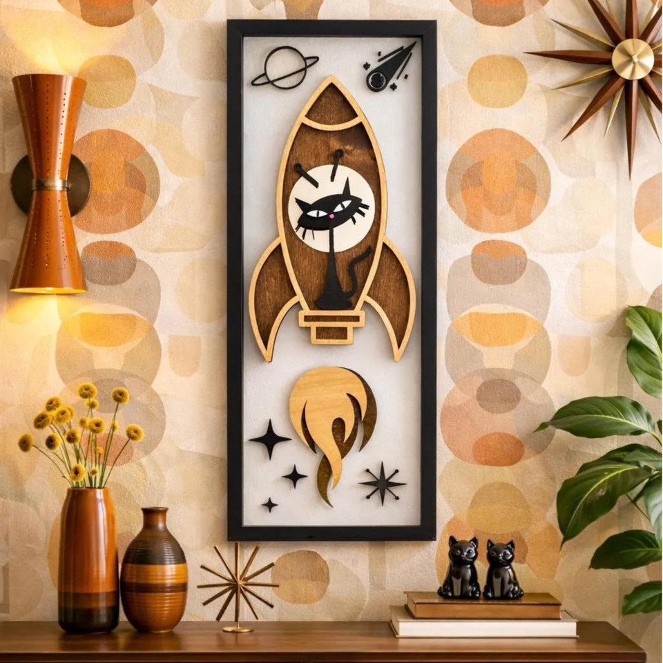 An atomic-age cat astronaut in space rendered in mid-century modern style — whimsical, nerdy, and aesthetically sharp all at once.