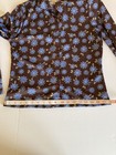 Brown and blue floral County Seat ladies shirt size M with button front, laid flat on measuring tape.