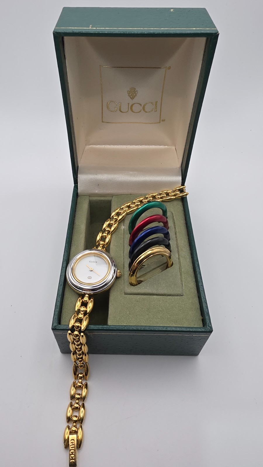 Gucci 1100L  Lady's Gold Plated Bracelet Watch with Six Interchangeable Bezels.