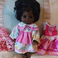 Vintage Black Hard Bodied doll opening and closing eyes outfit & 2 extra dresses
