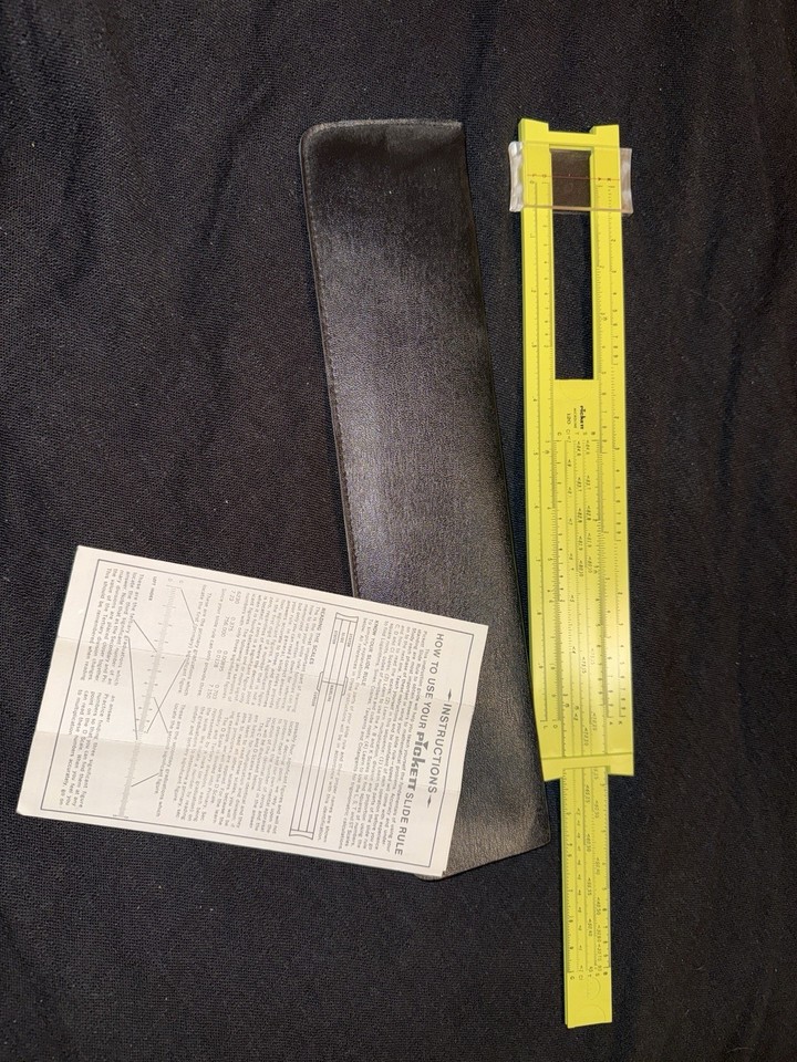 An iconic yellow Pickett slide rule with its original leather case and instruction sheet — the tool that helped send Apollo astronauts to the moon.