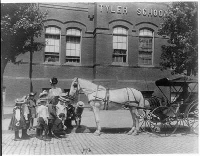Children studying a horse,buggy outside the Tyler 