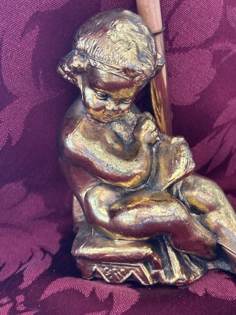 Gilded gold cherub motif pen holder that turns any desk into a little baroque shrine — maximalist and delightful.