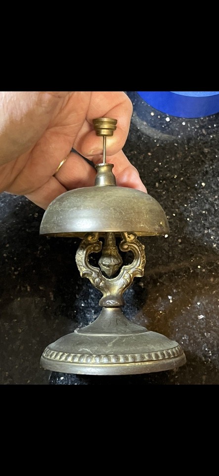 An ornate antique brass counter call bell in near-perfect condition — instant hotel-desk energy and a deeply satisfying *ding* for any home office.