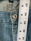 Blue stretch light wash Karen Kane women’s jeans with five-pocket design, silver button closure, and white measurement tape.