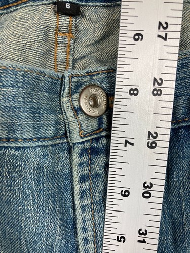 Blue stretch light wash Karen Kane women’s jeans with five-pocket design, silver button closure, and white measurement tape.
