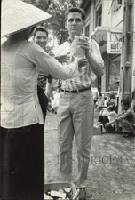 1966 Press Photo American in civilian clothes with sidewalk vendor in Saigon