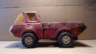 Red vintage 1970s Tonka No. 8.5 inch pressed steel pick-up truck with yellow wheels, mud tires, and white Tonka logo on hood.