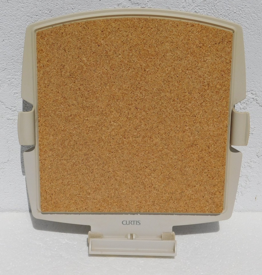 A clip-on cork board designed for a vintage 80s personal computer — a delightfully niche desk artifact from the dawn of the PC era.