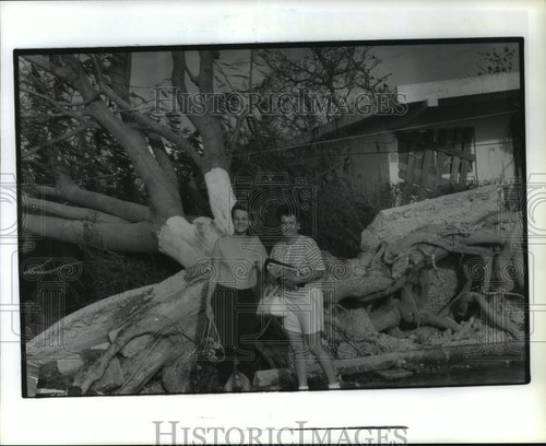 1988 Press Photo Women stand in front of downed tree after Hurricane Gilbert