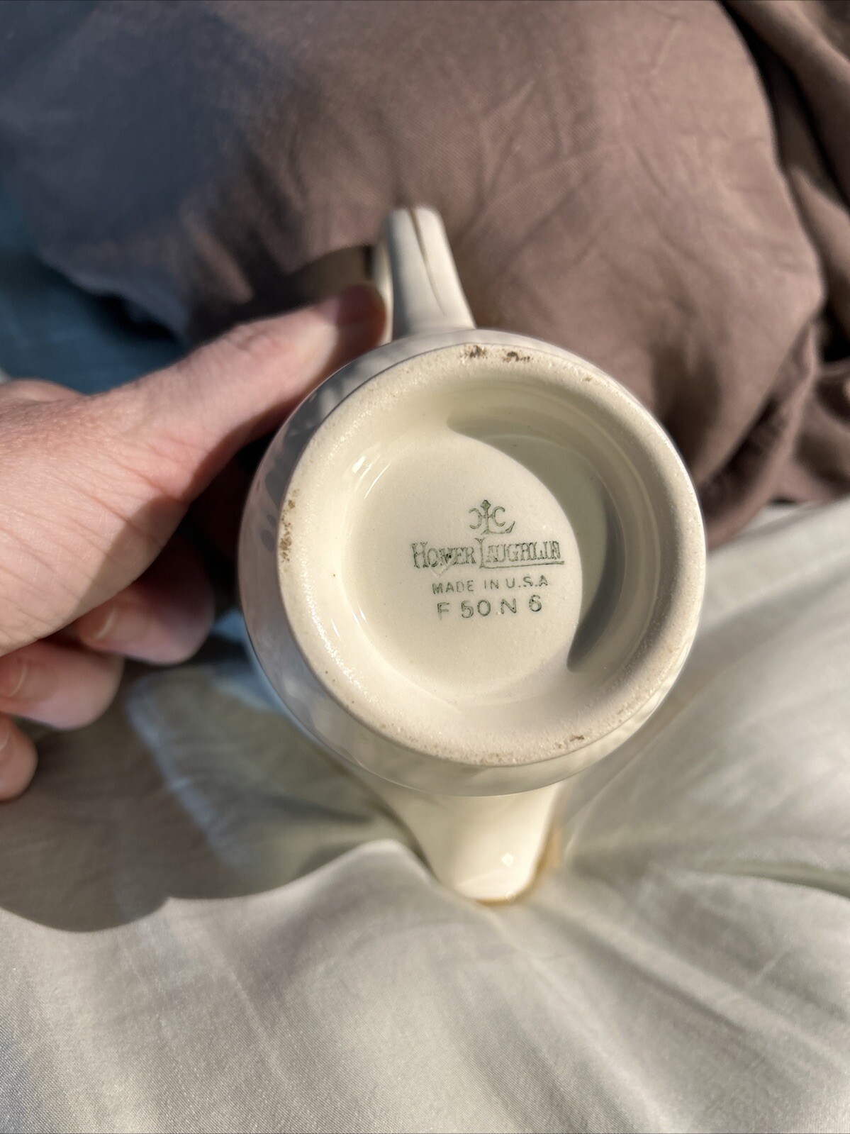 Cream ceramic mug with “Homer Laughlin Made in U.S.A. F 50 N 6” text on white porcelain base.