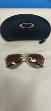 Oakley Caveat aviator sunglasses with a polished gold frame and brown gradient