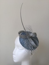 Blue fascinator with silver loops, feathers and netting on a silver headband 