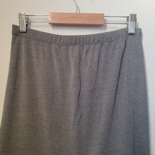 Grey maxi skirt with vertical tiered flowy panels, elastic waistband, and straight hem, hanging on a wooden hanger.
