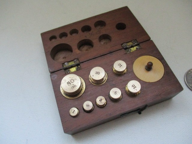 Antique apothecary metric weights set in a wooden case.