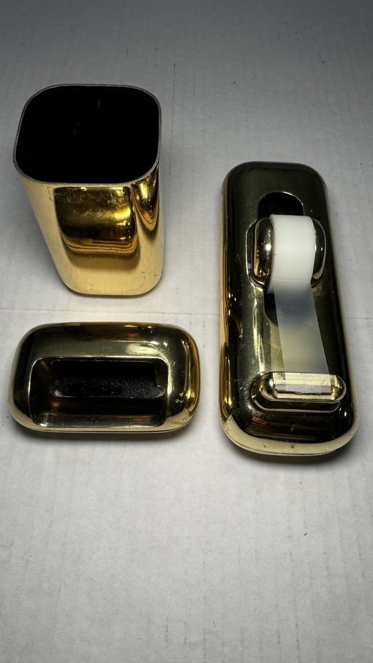 A matched 3-piece 1980s Eldon desk set in gleaming gold-tone finish — peak power-office maximalism, fully cohesive.