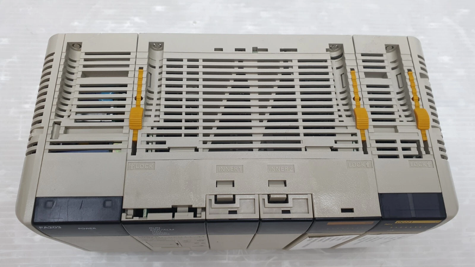 Vented side of the CQM1H-CPU11-TL PLC assembly with the module fronts along the edge