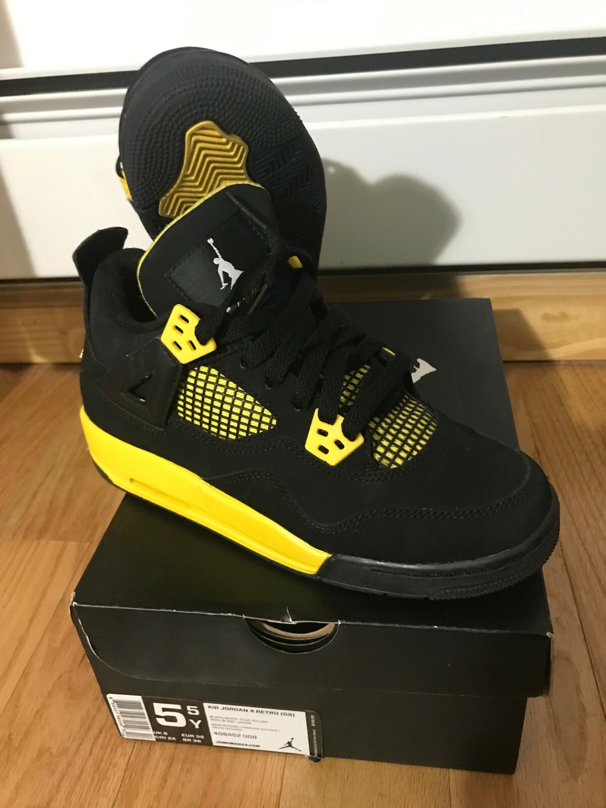 black and yellow jordan 4